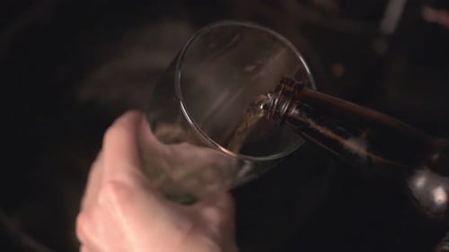 Man Pouring Beer Into A Tall Glass. -close up shot