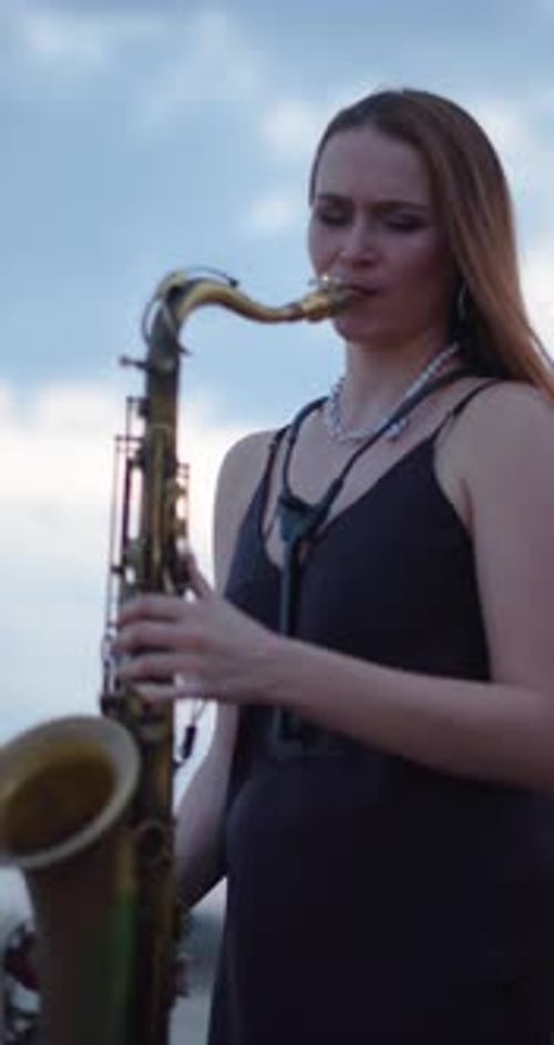 Woman Plays Saxophone Outside on Overcast Day