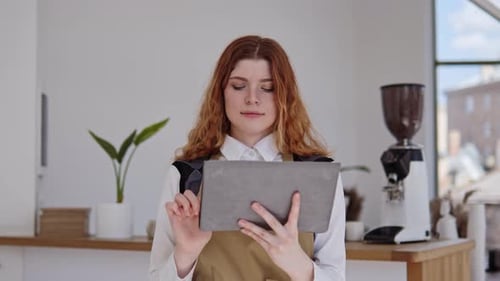 La exitosa propietaria de un café barista acepta pedidos en línea en una tableta