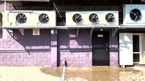 Front View of Air Conditioning System Installed on Wall Above the Door of Building with Rotating