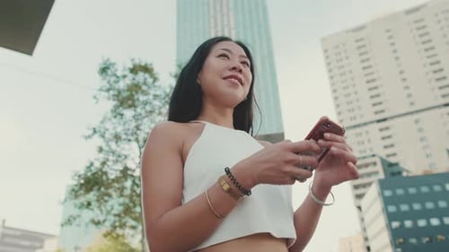 Young Woman Uses Phone in an Urban Setting