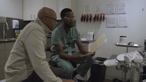 Male Doctor Discussing Test Results with Patient in Clinic Exam Room 10 Seconds or Greater