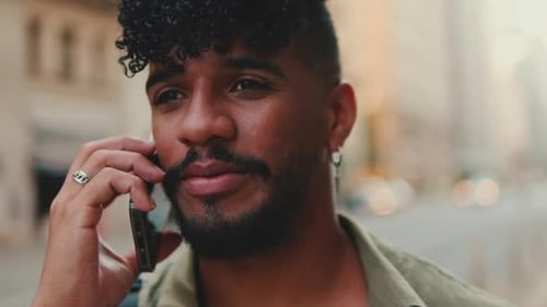 Portrait, close up of young happy man is talking on cellphone