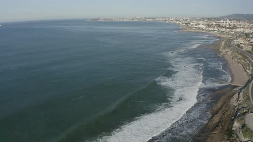 Aerial View of Ocean Waves on Coastal City