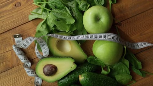Healthy Green Fruits And Vegetables With Measuring Tape On Wooden Table In Daylight