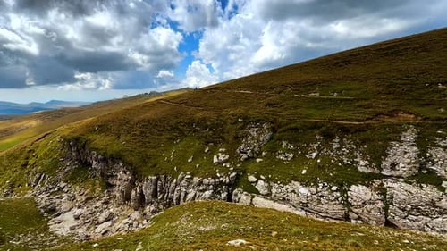 Green hills and rocky cliffs of Bucegi Mountains.