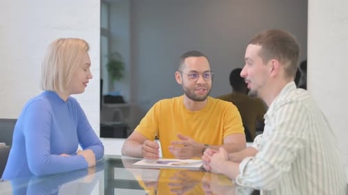 Three Colleagues Discussing Business at a Table