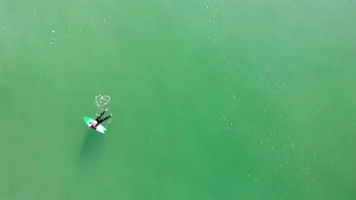 Overhead aerial 4k drone flyover of surfers and turbulent Pacific Ocean waves at Huntington Beach Ca