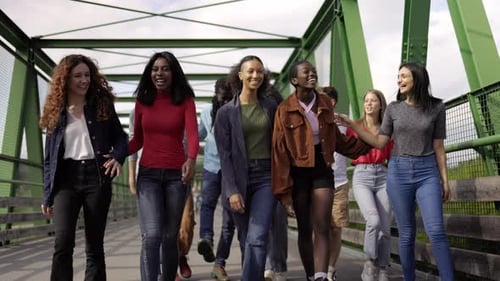 Happy multiracial group of friends having fun walking outdoor on city bridge