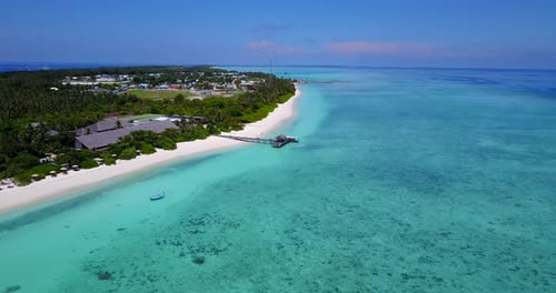 aerial view of a resort on the Maldives with white sandy beaches, and deep dark blue sea