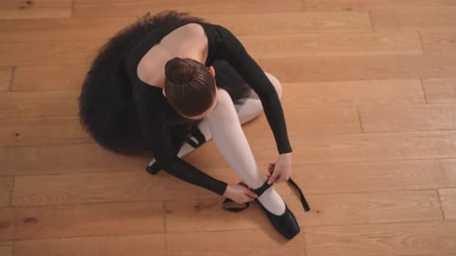 Ballerina Puts on Pointe Shoes on Leg in Dance Class Classical Ballet Dancer Woman in Dance Studio