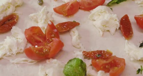Nahaufnahme der Hände eines Pizzabäcks beim Füllen einer Pizza mit hochwertigen italienischen gastronomischen Zutaten