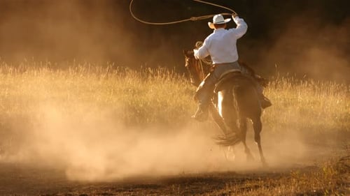 Cowboy cabalgando al atardecer,
