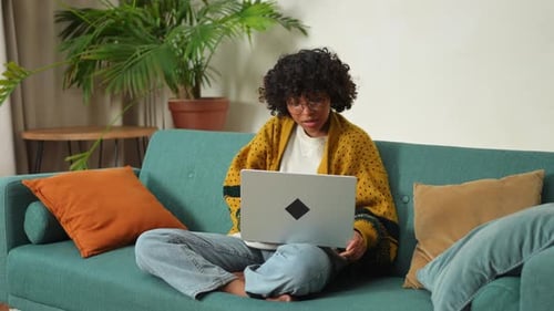 African American Girl Using Laptop at Home Office Looking at Screen Typing Chatting Reading Writing