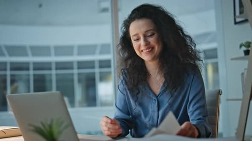 Smiling Woman Working at Desk Late Night