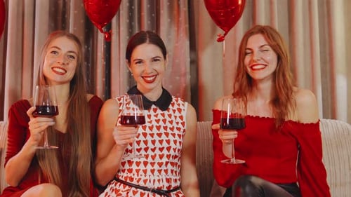 Three Smiling Women Celebrate with Wine