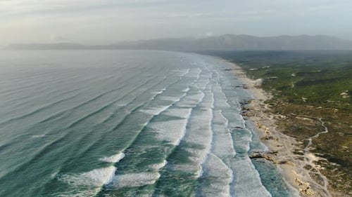 Majestic Aerial Views of Rolling Ocean Waves and Rugged Mountain Coastlines