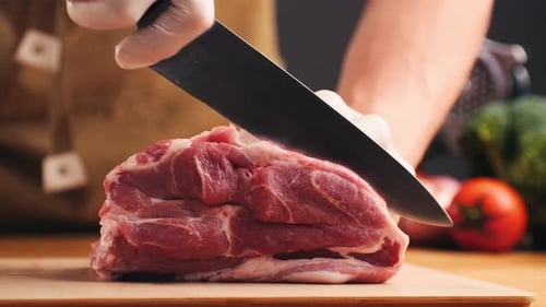 Adult Cutting Fresh Meat with a Knife
