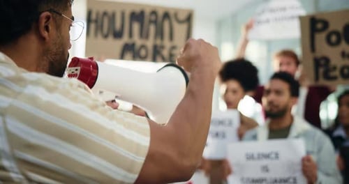 People Protesting With Megaphone and Signs Indoors