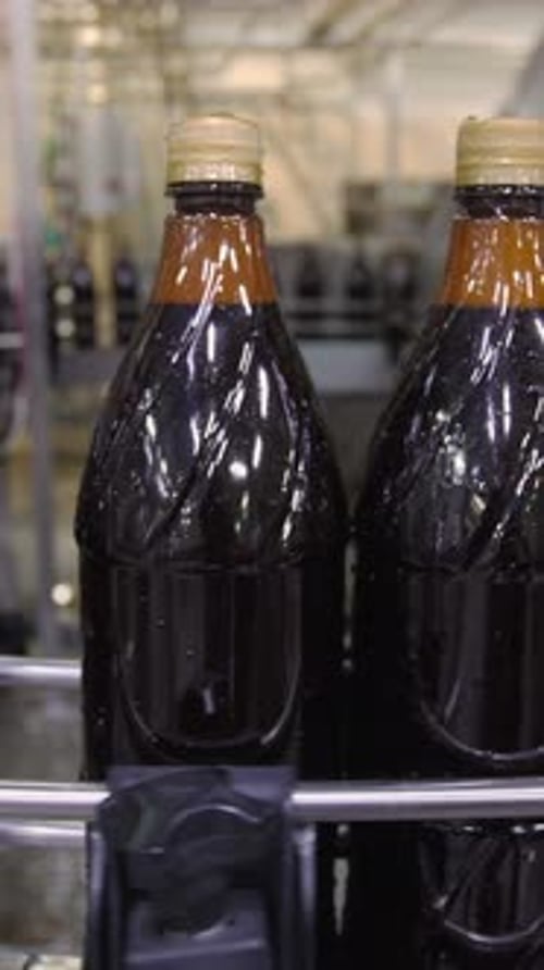 Bottling Process of Dark Beverage in Factory Setting During the Day