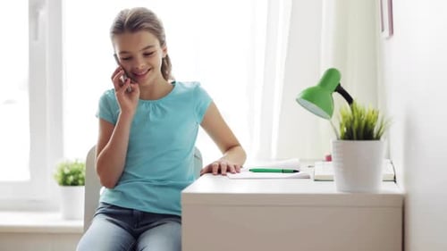 Girl Talking on Smartphone Sitting at Desk Indoors