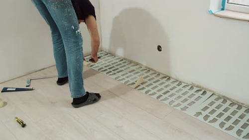 Man Installing New Laminate Flooring in Home