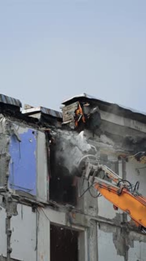 Destruction machine demolishes the ruined building.