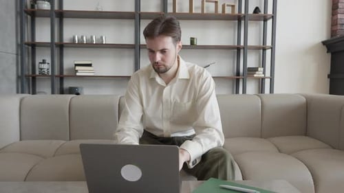 Serious Young Businessman Using Laptop Computer in Office