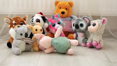 Stuffed and fluffy Pink Piglet plush toy falls on the laminate in the play area