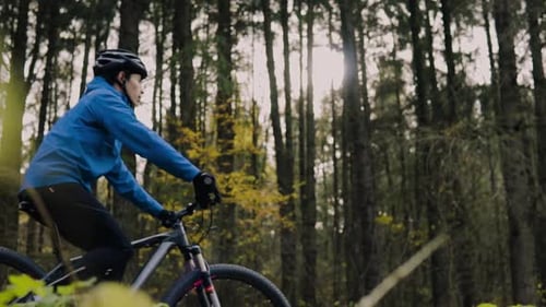 Young Man Riding Bicycle Outside in Autumn Nature