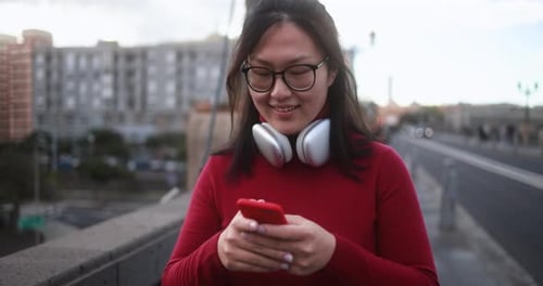 Young asian woman using mobile phone outdoor - City lifestyle concept