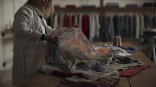 Italian seamstress prepares silk fabric in her sewing workshop for a new scarf