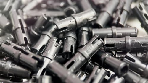 Pile of Shiny, Cylindrical, Dark Gray Pieces