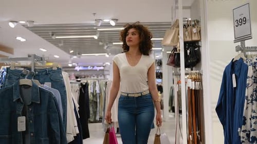 Woman Walking Through Clothing Store Aisles