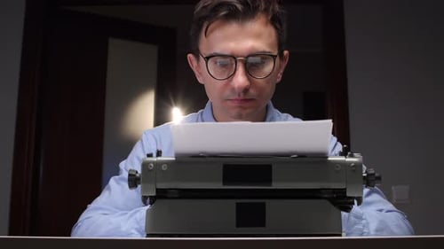 Man Typing on Typewriter in Dark Room