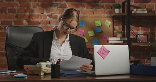 Young Businesswoman in Office with Brick Wall Background