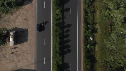 Top down shot of highway in India where more and more of the road is revealed as the drone flies up