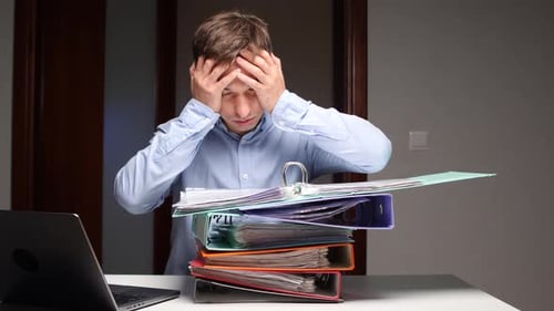 Man Experiencing Burnout with Overwhelming Office Paperwork Workload