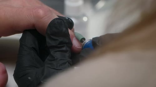 Close Up of Manicurist Shaping Nail with Tool