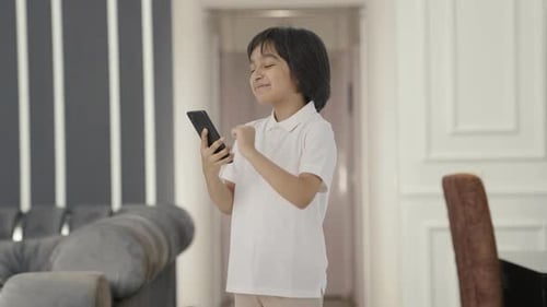 Happy Child Using Smartphone in Modern Home