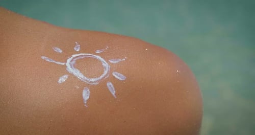 Ein junges und hübsches Mädchen verwendet Cremes, um sich vor den UV-Strahlen der Sonne zu schützen, um