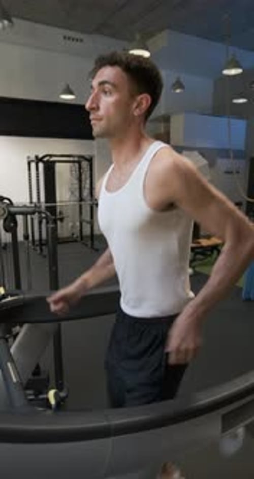 Homem suando enquanto corre em uma esteira na academia