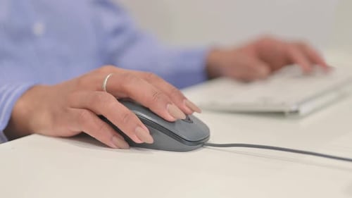 Woman Using a Computer Mouse at Work