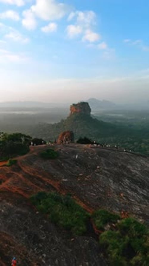À distance du rocher de Pidurangala avec des passants. Forteresse rocheuse de Sigiriya
en toile de fond