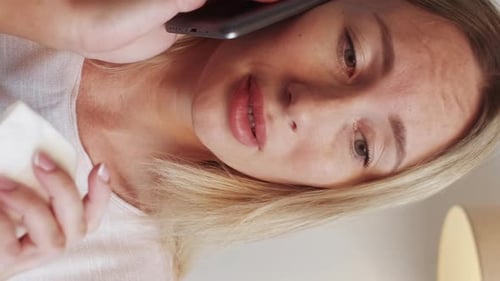 Woman Talks on Phone, Uses Tissue Close Up