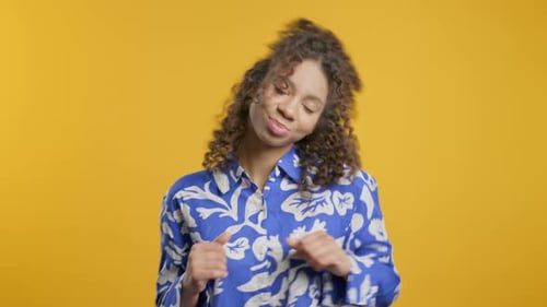 Happy African Woman Dancing on Yellow Studio Background Favorite Music Smiling