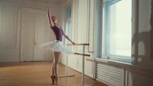 Young Ballerina Practices at the Barre in Studio