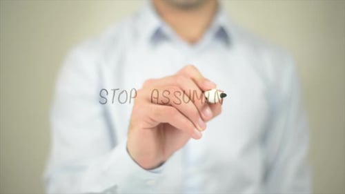 Stop Assuming, Man Writing on Transparent Screen