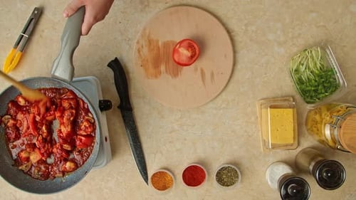 Tomato sauce cooking in pan with ingredients overhead