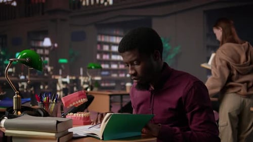 African American Student Examining Fake Teeth for Dentistry Thesis